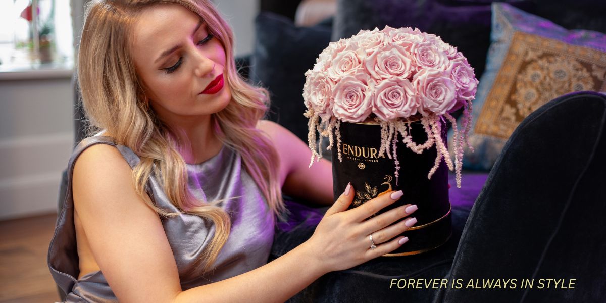 A girl holding a bloom box in hand and looking on it